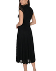 Model wearing a black The Strawberry Shop Frank Lyman midi dress with lace cap sleeves and a high neckline