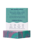 The Strawberry Shop Dr. Squatch Under The Suds soap bar with green and purple swirls and its teal product packaging.