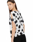 The Strawberry Shop white short-sleeve top with black polka dots and cut-out details on sleeves. Made of polyester and spandex.