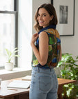 The Strawberry Shop sleeveless collared blouse with abstract art print in green, blue, yellow, and red. Features navy contrast placket and buttons.
