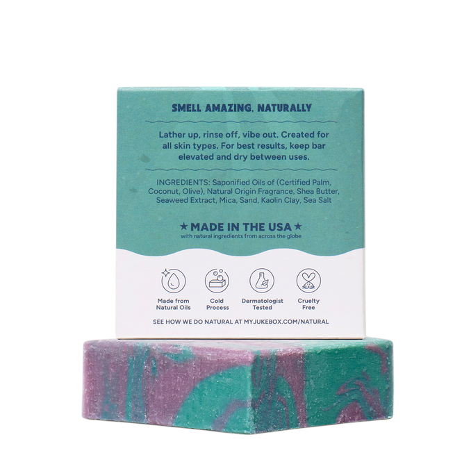 The Strawberry Shop Dr. Squatch Under The Suds soap bar with green and purple swirls and its teal product packaging.