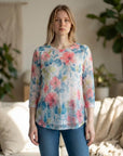 The Strawberry Shop floral openwork knit top with 3/4 mesh sleeves in pink, blue, and green on a model.