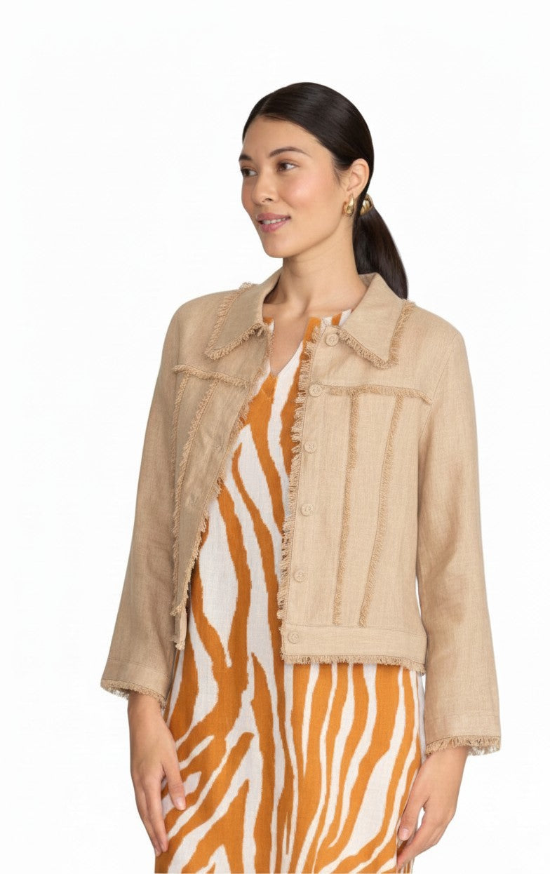 Model wearing The Strawberry Shop FOIL sand linen jacket with fringe trim over a patterned dress