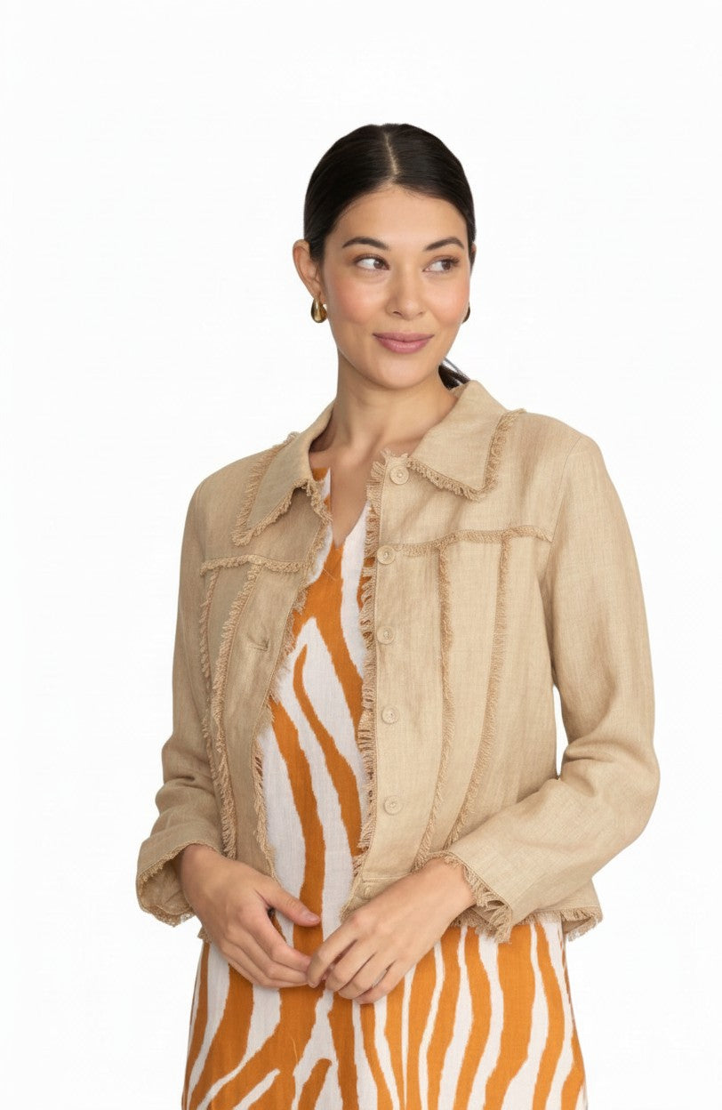 Model wearing The Strawberry Shop FOIL sand linen jacket with fringe trim over a patterned dress