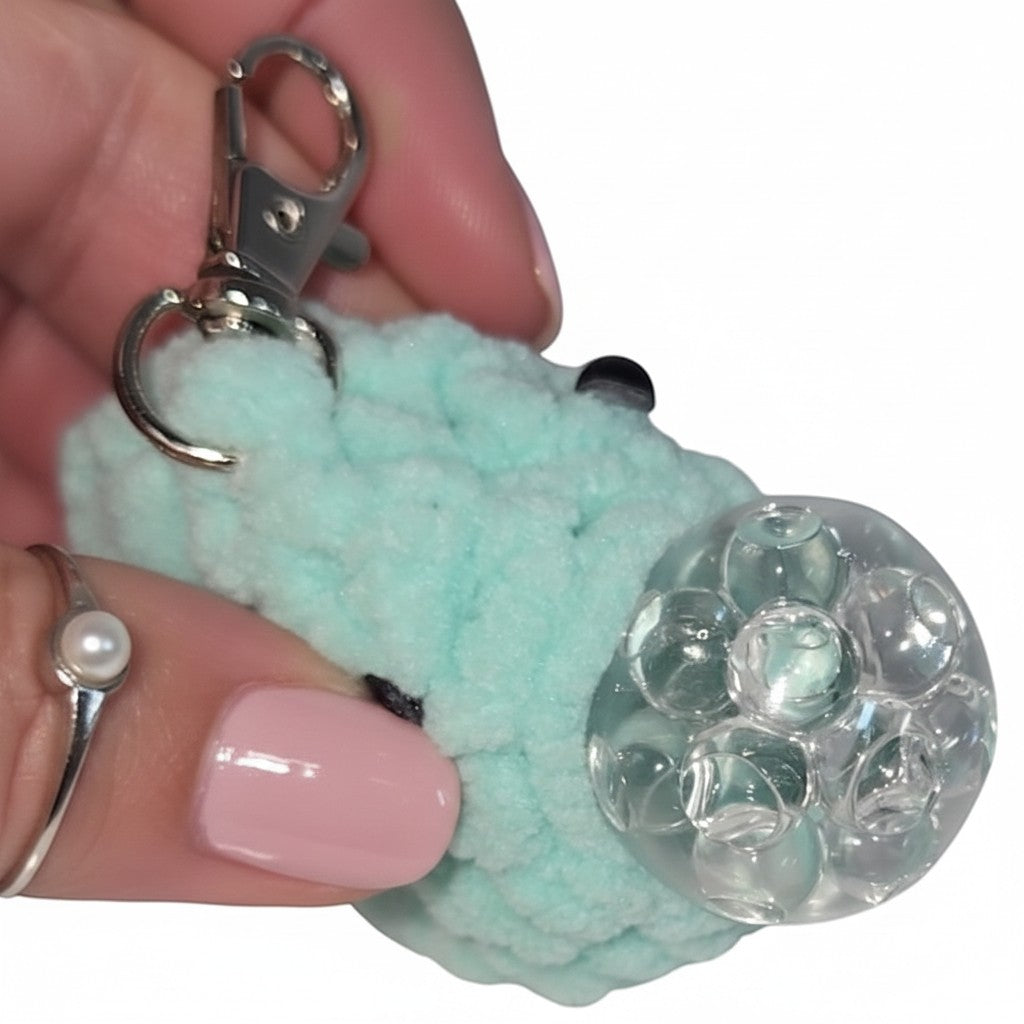 The Strawberry Shop mint green crochet blob keychain with a squishy gel bead stress ball center and silver clasp.