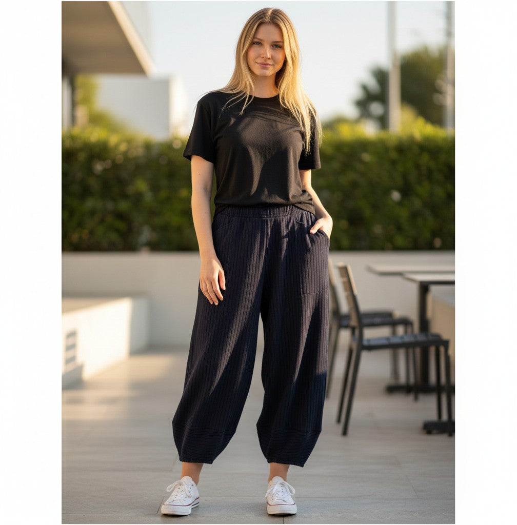 The Strawberry Shop Kleen Pants in navy blue with a ribbed texture, elastic waist, and tapered ankles on a model.