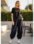 The Strawberry Shop Kleen Pants in navy blue with a ribbed texture, elastic waist, and tapered ankles on a model.