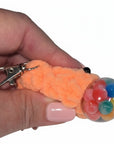The Strawberry Shop orange crochet blob keychain with googly eyes and a clear squishy ball filled with colorful beads.