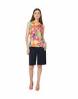 The Strawberry Shop white knee-length shorts with a flat front and tailored fit, paired with a colorful floral sleeveless top.