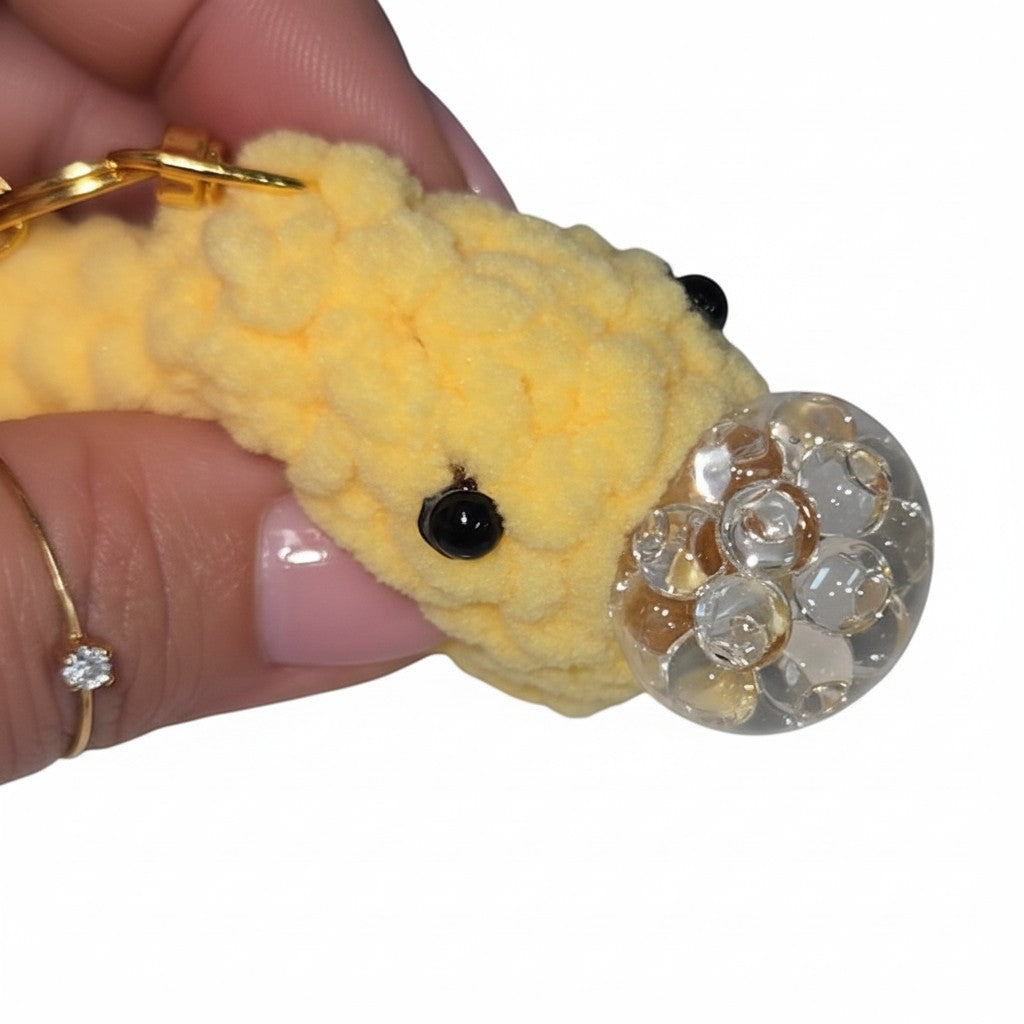 The Strawberry Shop yellow crochet smiley face keychain with a clear bubble charm and gold lobster clasp.
