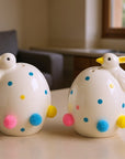 The Strawberry Shop white ceramic Easter egg shaped salt and pepper shakers with duck heads, blue, pink, and yellow pom-poms.