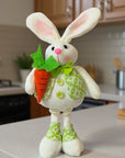 The Strawberry Shop white polyester standing bunny decor holding a carrot, wearing a green patterned vest and bow tie.